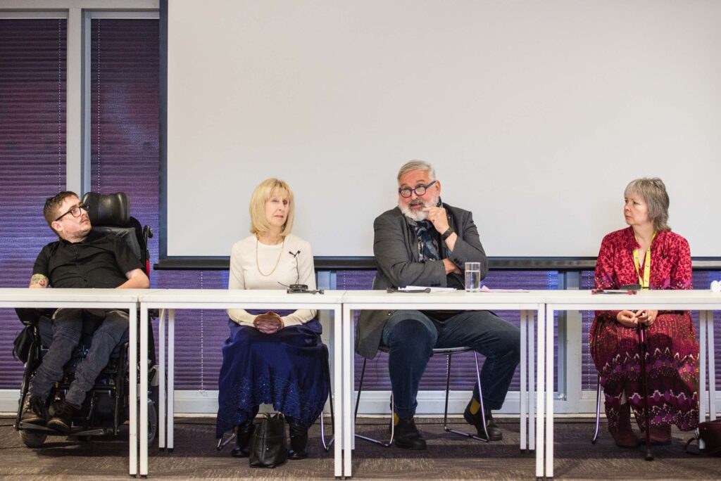 Road to Rights panel members sitting by a long table. From left to right: Joshua Reeves, Andrea Gordon, Graham Findlay and Rhian Davies.