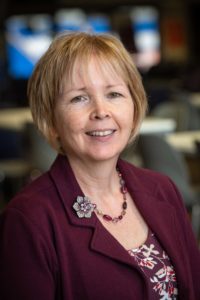 Rhian who has short light hair smiling at the camera